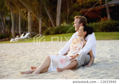 Couple sitting on beach 11633940
