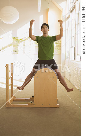Asian man sitting in exercise equipment 11633949