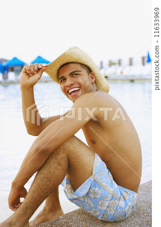 Hispanic man sitting next to swimming pool 11633969