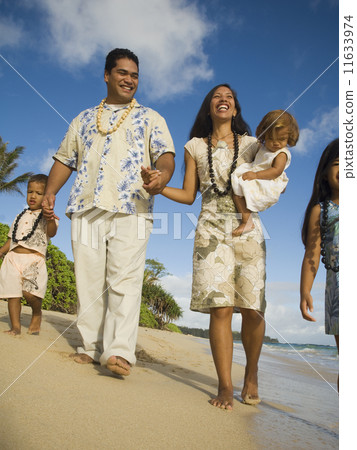 Pacific Islander family walking on beach Pacific Islander family walking on beach 11633974