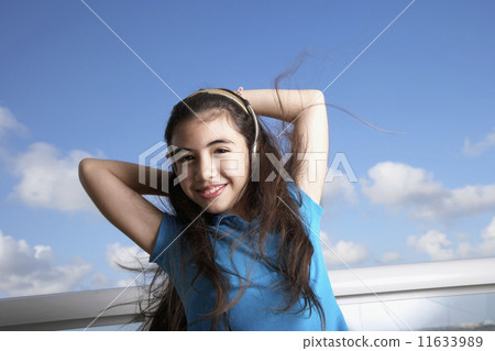 Hispanic girl listening to headphones Hispanic girl listening to headphones 11633989