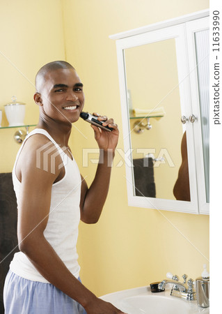African man shaving with electric razor 11633990