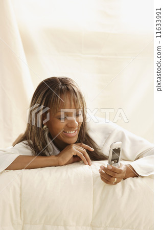 African woman smiling at cell phone 11633991