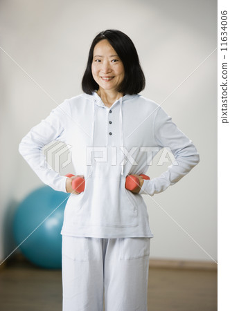 Asian woman lifting weights 11634006