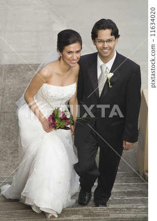 Hispanic bride and groom on steps 11634020