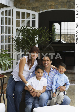 Hispanic family sitting on patio 11634024