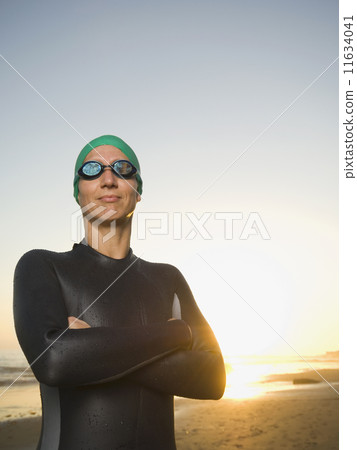 Hispanic woman wearing wetsuit and goggles Hispanic woman wearing wetsuit and goggles 11634041