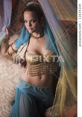 Woman in belly dancing outfit on bed Woman in belly dancing outfit on bed 11634104
