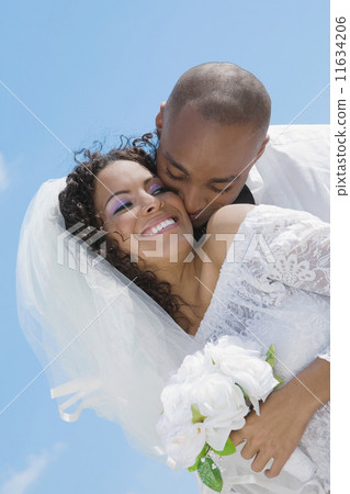 Multi-ethnic bride and groom hugging 11634206