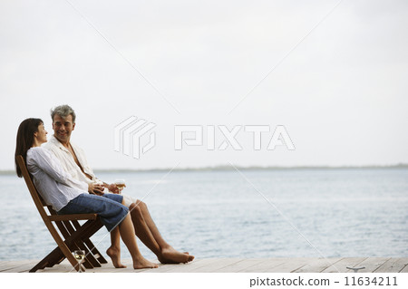 South American couple sitting on dock 11634211