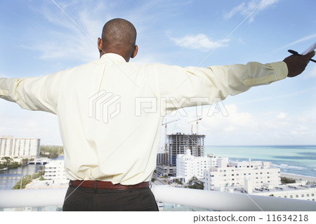 Rear view of African businessman on balcony 11634218