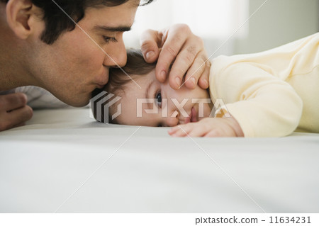 Hispanic father kissing baby Hispanic father kissing baby 11634231