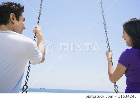 Asian couple swinging on swings 11634243