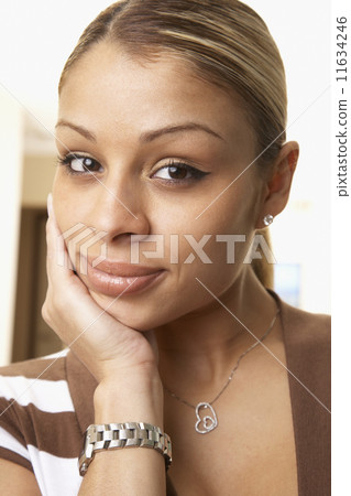 Hispanic woman resting chin in hand 11634246