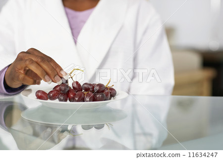 African American woman eating grapes 11634247