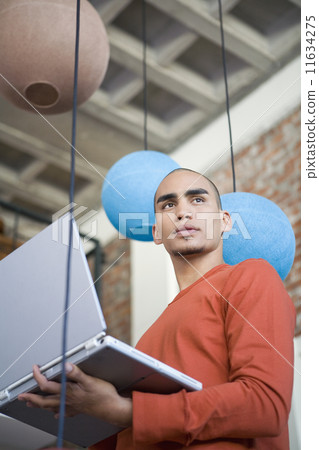 African American man holding laptop 11634275