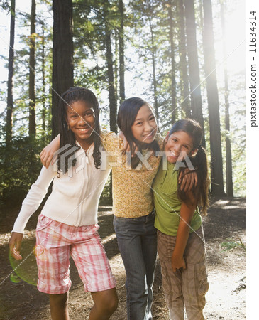Multi-ethnic girls hugging in woods Multi-ethnic girls hugging in woods 11634314