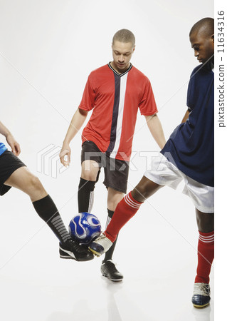 Multi-ethnic male soccer players with ball 11634316