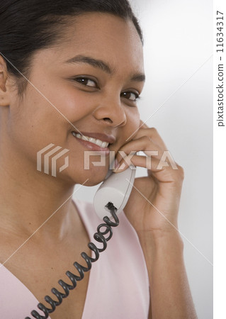 Indian woman talking on telephone Indian woman talking on telephone 11634317