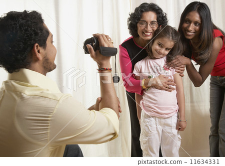 Stock Photo: Indian father video recording family