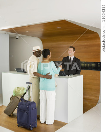 Senior African couple at hotel counter 11634355