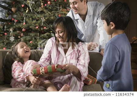 Hispanic family opening gifts on Christmas 11634374