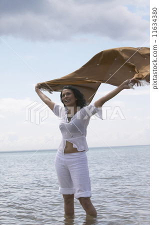 Woman standing in water with shawl flowing out behind her 11634380
