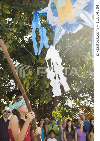 Hispanic girl trying to hit pinata 11634384