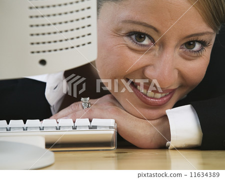 Portrait of businesswoman leaning on desk Portrait of businesswoman leaning on desk 11634389