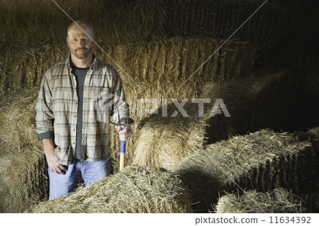Portrait of male farmer in hay barn Portrait of male farmer in hay barn 11634392