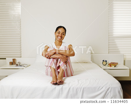 African woman sitting on bed 11634405