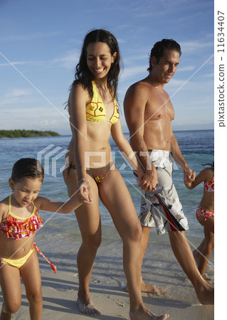 Hispanic family holding hands at beach 11634407