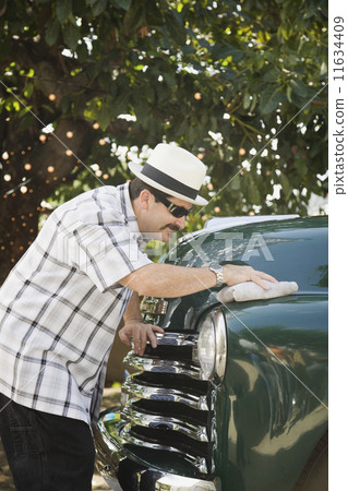 Hispanic man waxing truck 11634409