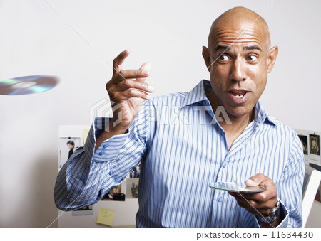 African businessman throwing cds in office African businessman throwing cds in office 11634430