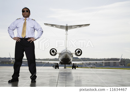 Asian male pilot with airplane in background Asian male pilot with airplane in background 11634467