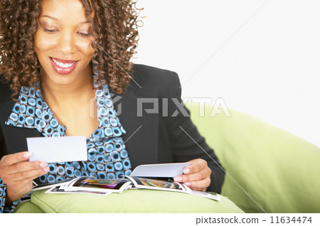 Woman looking at photographs Woman looking at photographs 11634474