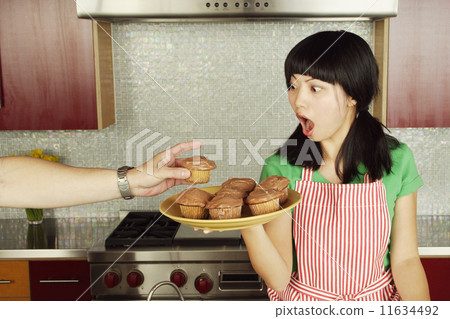 Man stealing cupcake from platter 11634492