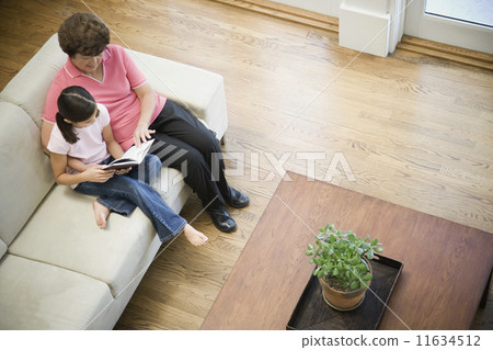 High angle view of Asian grandmother and granddaughter reading High angle view of Asian grandmother and granddaughter reading 11634512
