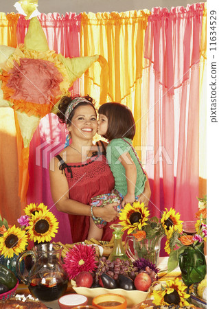 Mixed Race mother and daughter behind buffet table 11634529