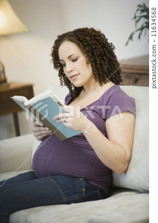 Pregnant African woman reading 11634568