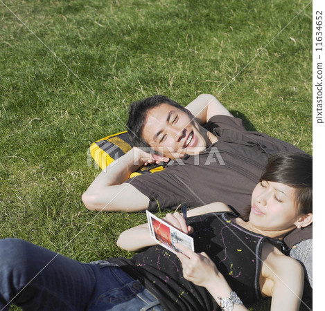 Young couple relaxing in grass Young couple relaxing in grass 11634652