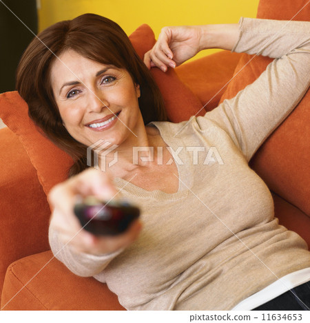 Hispanic woman pointing remote control 11634653