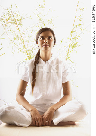 Young woman sitting on the floor meditating 11634660