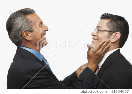 Hispanic businessman smiling at younger businessman 11634667