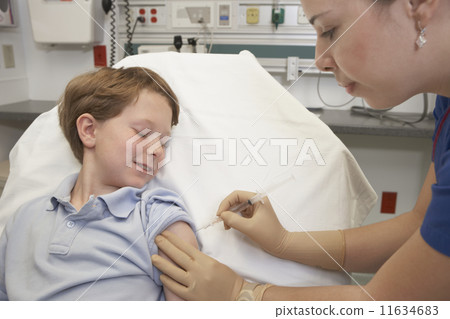 Young boy receiving injection from nurse 11634683