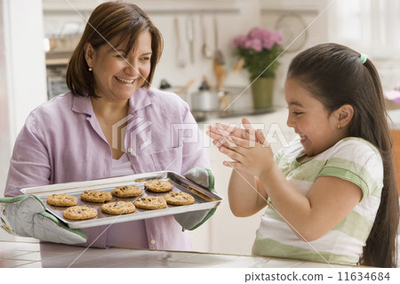 Hispanic mother and daughter with tray of cookies 11634684