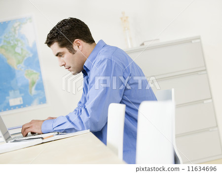 Hispanic man typing on laptop 11634696