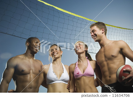 Multi-ethnic friends under beach volleyball net 11634706