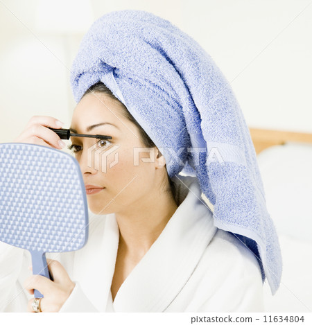 Hispanic woman applying mascara Hispanic woman applying mascara 11634804