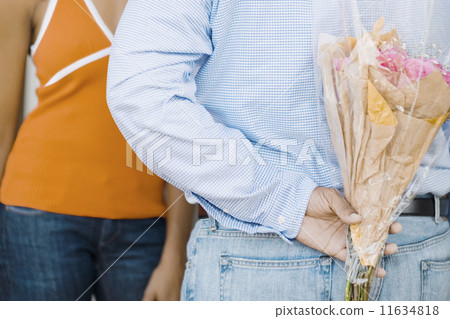 African man surprising girlfriend with flowers 11634818